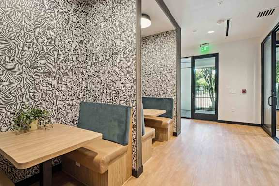 A room with a wooden table and a green cushion.