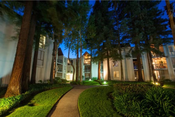 Pathway leading to apartment homes overlooking trees and lush green areas at Castlewood Apartments in Walnut Creek, California, 94596