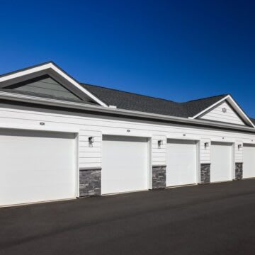 A white house with a black roof and four garage doors.at 198 Milltown Apartments, Burlington, NC