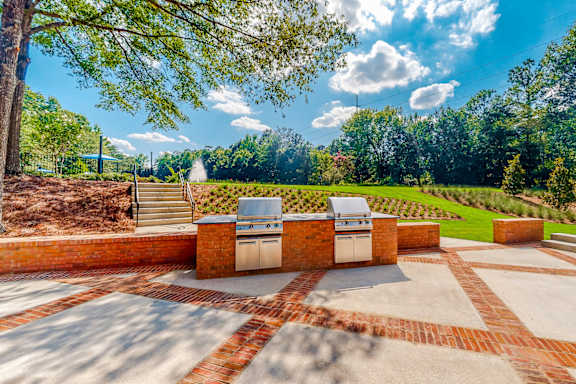 a patio with a barbecue grill and a view of a garden at Inverness Cliffs, Alabama