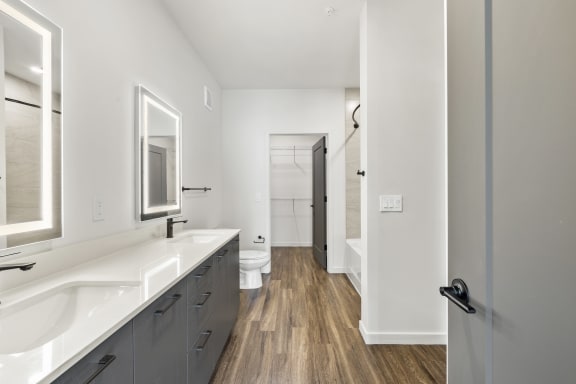 Spacious bathroom with gray cabinets, white quartz countertops, and soaking tub at Azalea, Luxury Tampa Apartments