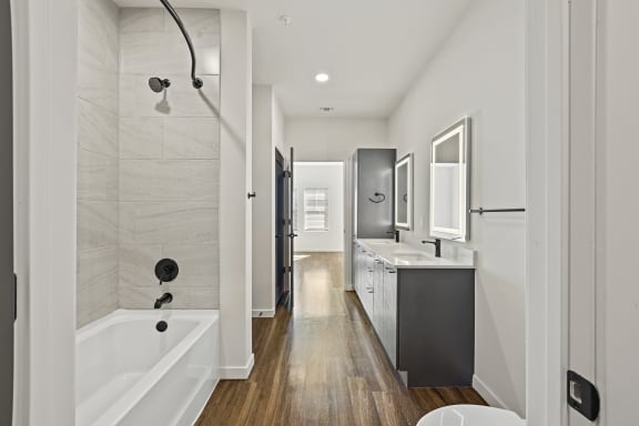 Renovated bathroom with bathtub, wood floors, and modern fixtures  at Azalea, Luxury Tampa Apartments