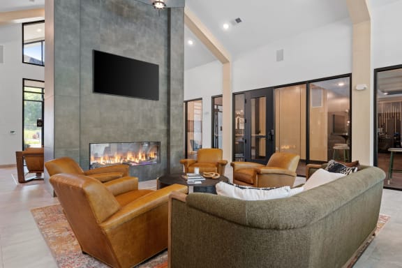 a living room with a couch and chairs and a fireplace at The Lodge at Overland, Rochester, MN