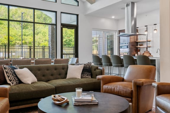a living room with couches and chairs and large windows at The Lodge at Overland, Rochester
