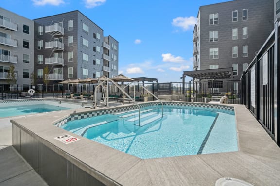 a swimming pool with two apartment buildings in the background