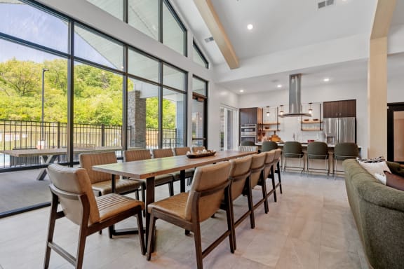a dining room with a long wooden table and chairs at The Lodge at Overland, Rochester, 55901