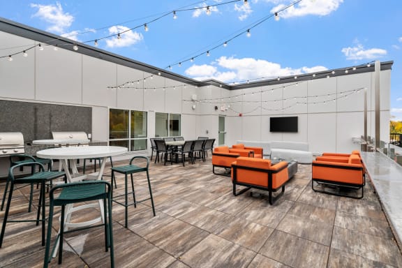 a patio with tables and chairs and a tv at The Aurilla, Minnesota