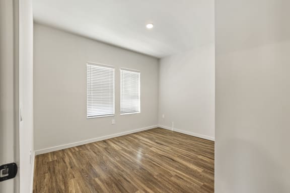 Bedroom with wood flooring and tons of natural light at Azalea Luxury Tampa Apartments