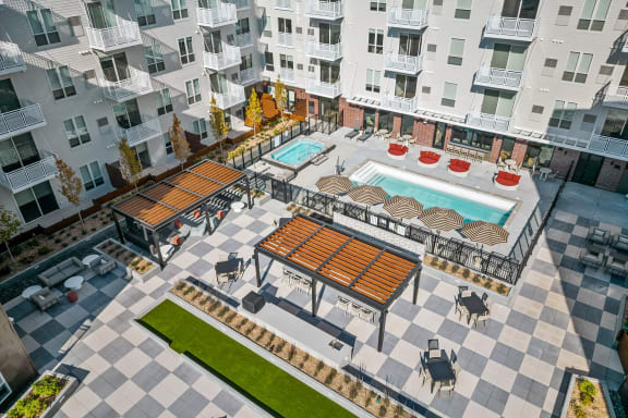 an aerial view of an apartment complex with a pool and patio furniture