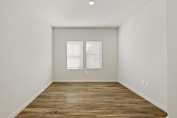 A bedroom with white walls and wood flooring at Azalea, Luxury Tampa Apartments