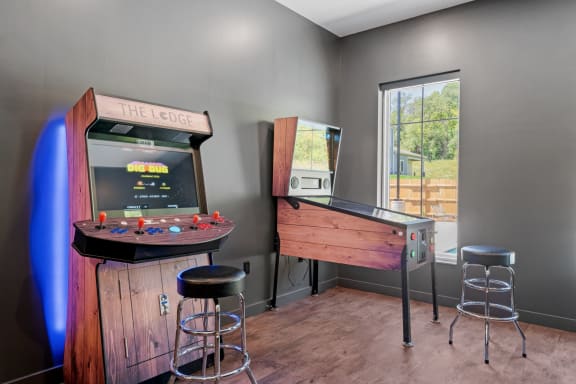 the lodge has a game room with a bar and a 1960s arcade machine at The Lodge at Overland, Rochester