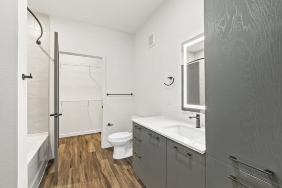 Modern bathroom with ring light mirror and black fixtures at Azalea Luxury Tampa Apartments