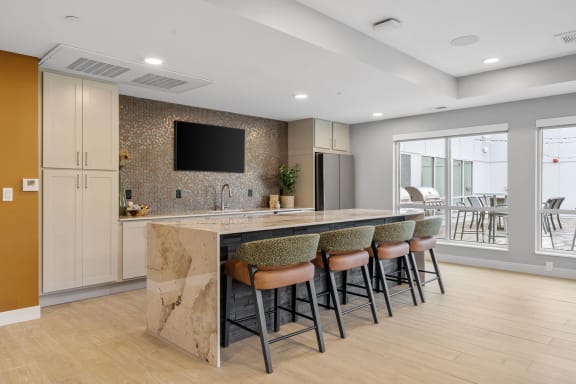 a kitchen with a marble counter top and bar stools at The Aurilla, Cottage Grove, Minnesota