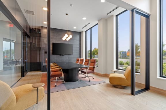 a conference room with a table and chairs and a television