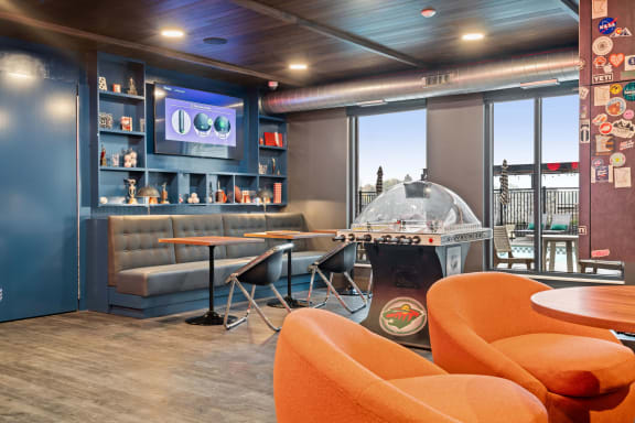 Lounge area with orange chairs at The Hallon, Hopkins, MN, 55343