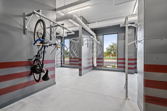 a bike hanging on a rack in a room with red and white stripes