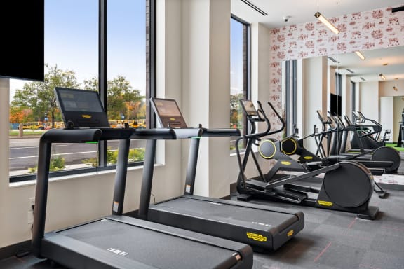 a row of treadmills in the gym of a hotel room