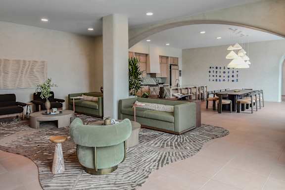 A living room with a green sofa and a patterned rug.