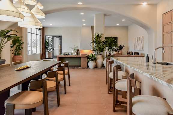 A kitchen with a long table and chairs.