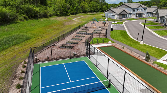 a tennis court is next to a fenced in tennis court at The Lodge at Overland, Rochester