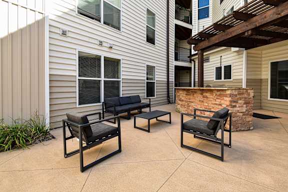 A patio with two black chairs and a table.