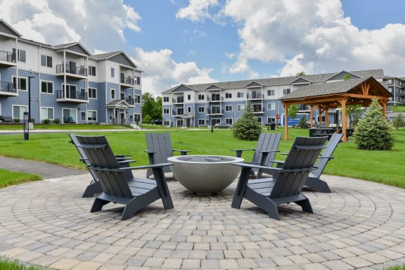 an outdoor patio with chairs and a fire pit at The Lodge at Overland, Rochester, MN