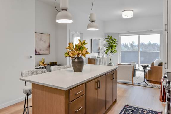 A kitchen with a white countertop and wooden cabinets.