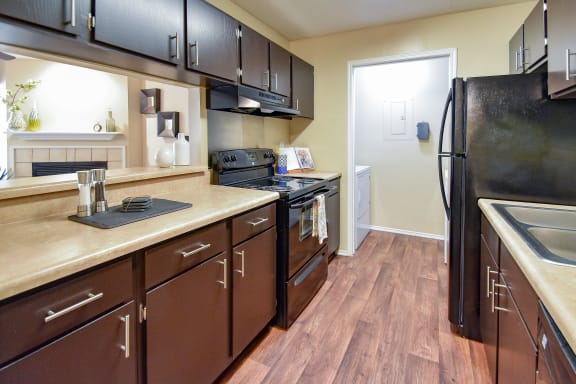 a kitchen with black cabinets and a wood floor &#xA0;at Riverset Apartments, Memphis