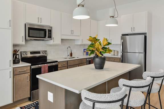A kitchen with a table and chairs and a vase of flowers.