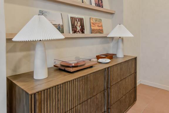 A wooden cabinet with a lamp and a book on top.
