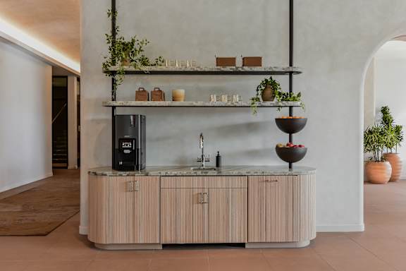 A modern kitchen with a wooden counter and a black fridge.