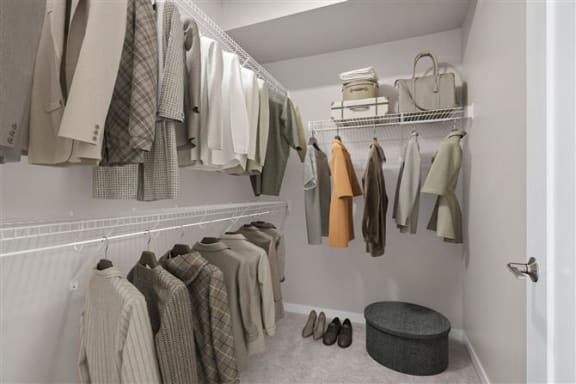 a walk in closet with a rack of clothes