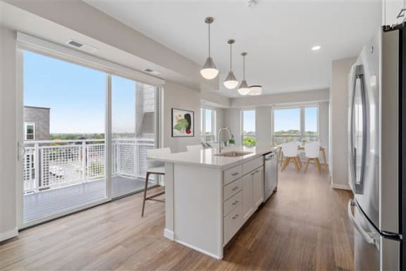 a white kitchen with a large island and a large window