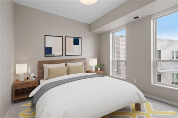 a bedroom with a large bed and two windows