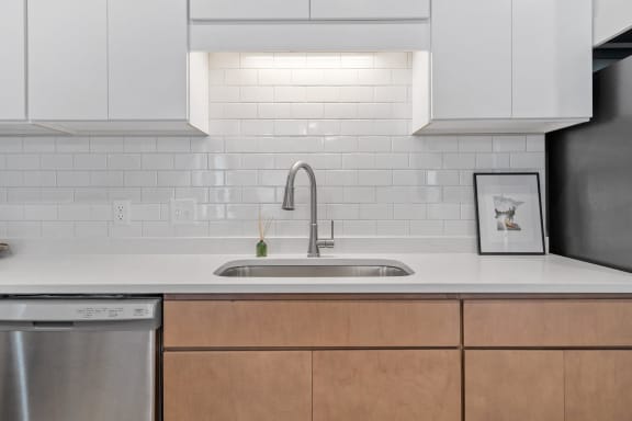 a kitchen with white countertops and wooden cabinets at The Aurilla, Minnesota