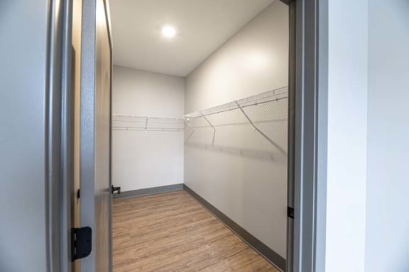 a white room with a mirrored closet and a door at The Commons at Rivertown, Grandville, MI, 49418
