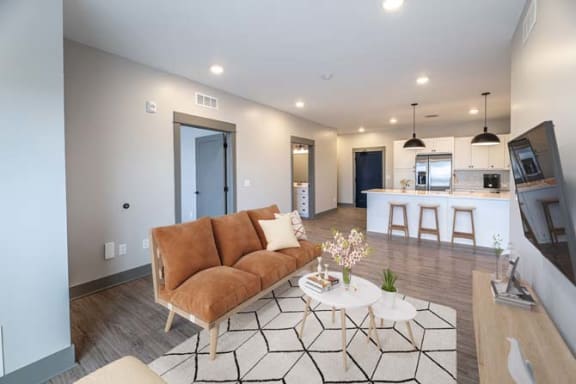 a living room with a couch and a kitchen at The Commons at Rivertown, Grandville, MI, 49418