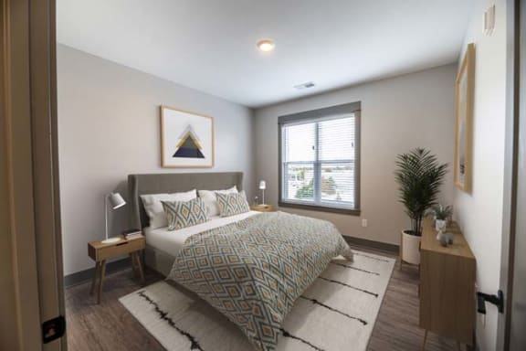 a bedroom with a bed and a window at The Commons at Rivertown, Grandville, MI, 49418