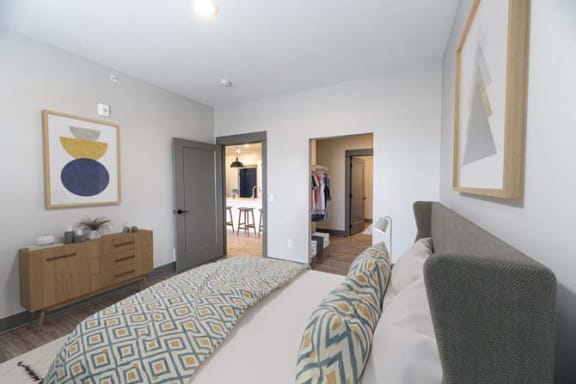 a bedroom with a large bed and a closet at The Commons at Rivertown, Grandville, Michigan