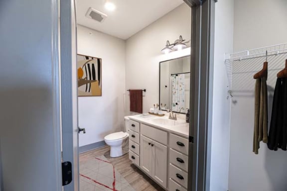 a bathroom with a toilet and a sink and a mirror at The Commons at Rivertown, Michigan, 49418