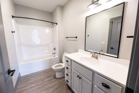 a bathroom with a sink toilet and a mirror at The Commons at Rivertown, Grandville, MI, 49418