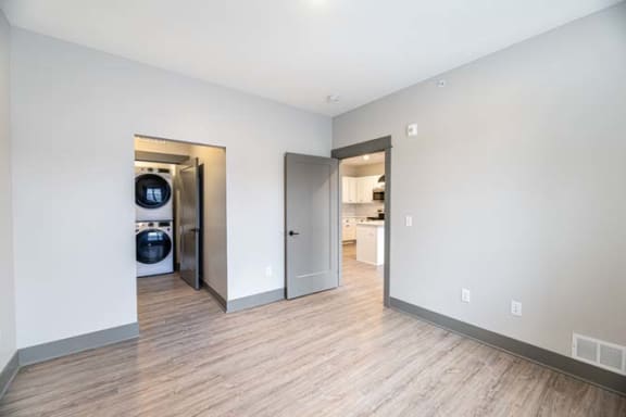 a living room and laundry room with a wood floor at The Commons at Rivertown, Grandville