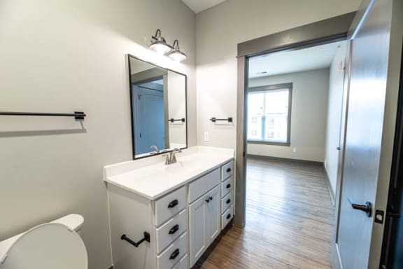 a bathroom with a sink and a mirror and a toilet at The Commons at Rivertown, Grandville, MI