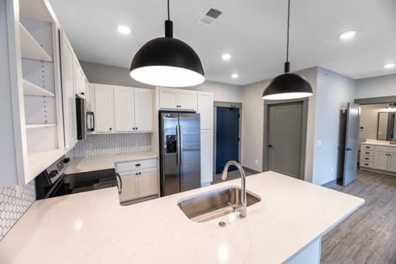 a white kitchen with a sink and a refrigerator at The Commons at Rivertown, Grandville, Michigan