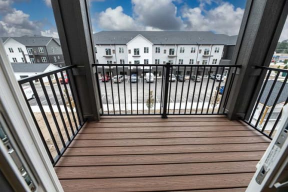 a balcony with a view of a building and the ocean at The Commons at Rivertown, Grandville