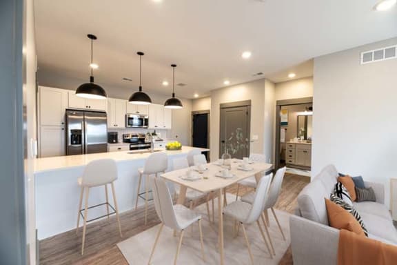 a kitchen and dining room with a table and chairs at The Commons at Rivertown, Grandville, MI