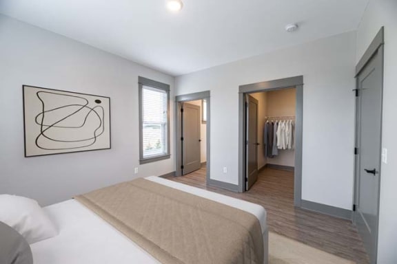 a bedroom with a bed and a closet at The Commons at Rivertown, Grandville, Michigan