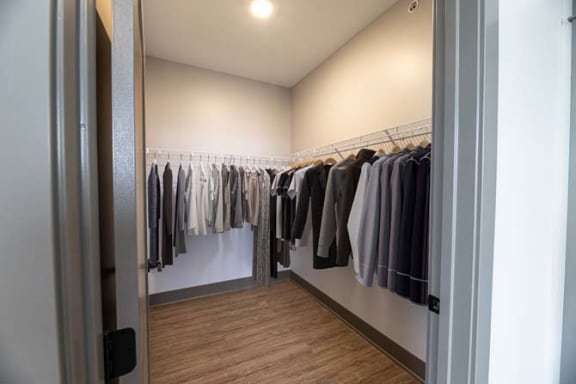 a walk in closet with a rack of clothes at The Commons at Rivertown, Grandville, MI