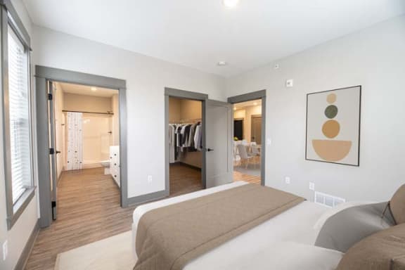 a bedroom with a large bed and a closet at The Commons at Rivertown, Grandville, MI, 49418