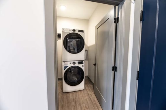a laundry room with a washing machine and a dryer at The Commons at Rivertown, Grandville, MI, 49418